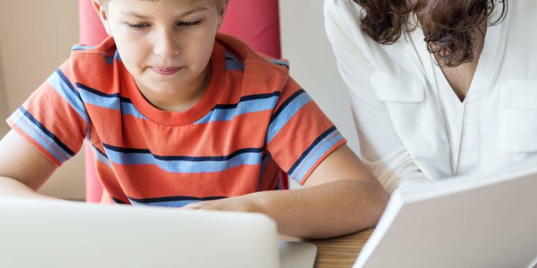 Fotografia di Bambino e mamma che insieme fanno didattica a distanza