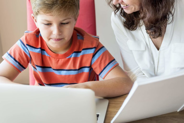 Fotografia di Bambino e mamma che insieme fanno didattica a distanza