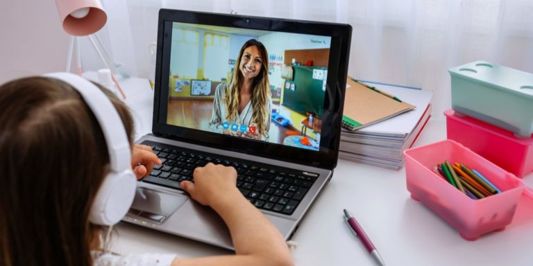 Fotografia di una bambina segue lezioni a distanza al computer