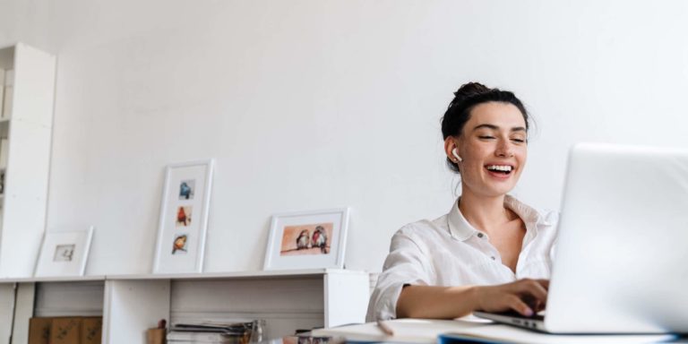 Fotografia di una insegnante che sorride mentre fa una videocall al suo computer portatile