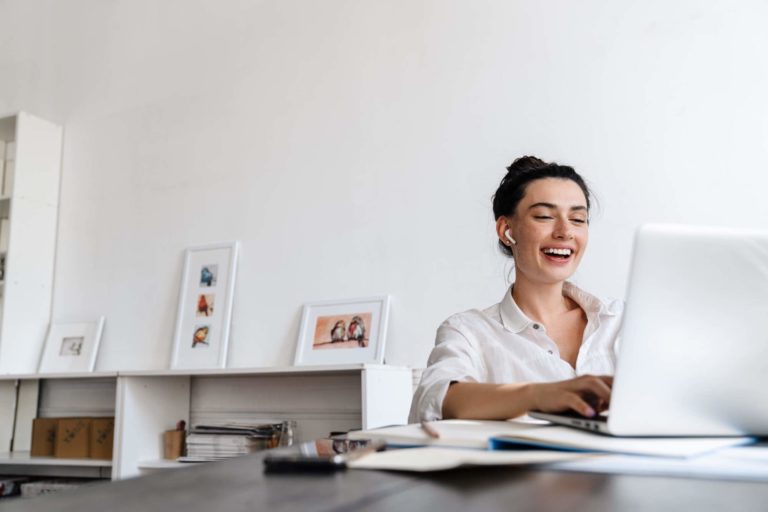 Fotografia di una insegnante che sorride mentre fa una videocall al suo computer portatile