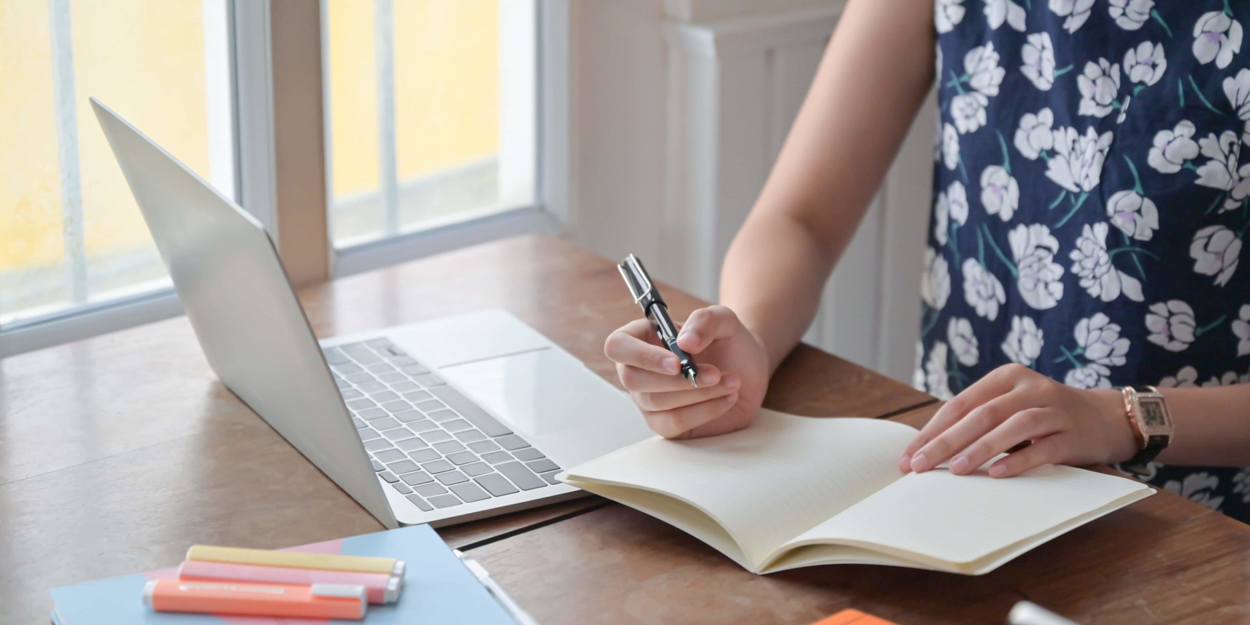 Fotografia di una insegnante che prende appunti davanti al computer