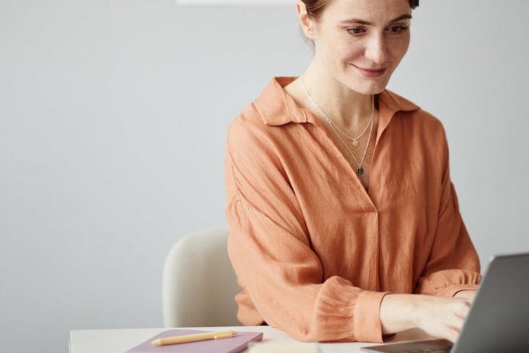 Fotografia di insegnante che lavora sorridente al suo computer portatile