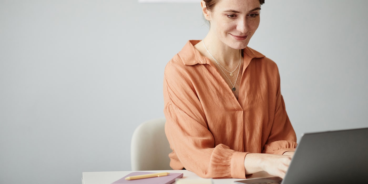 Fotografia di insegnante che lavora sorridente al suo computer portatile
