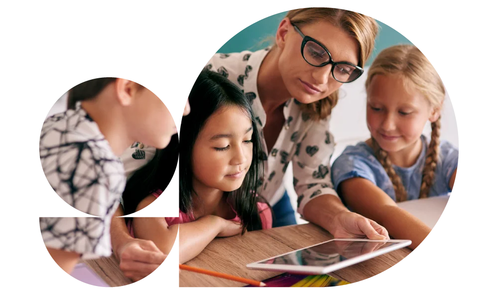 Fotografia di bambini in classe che guardano un tablet assieme all'insegnante